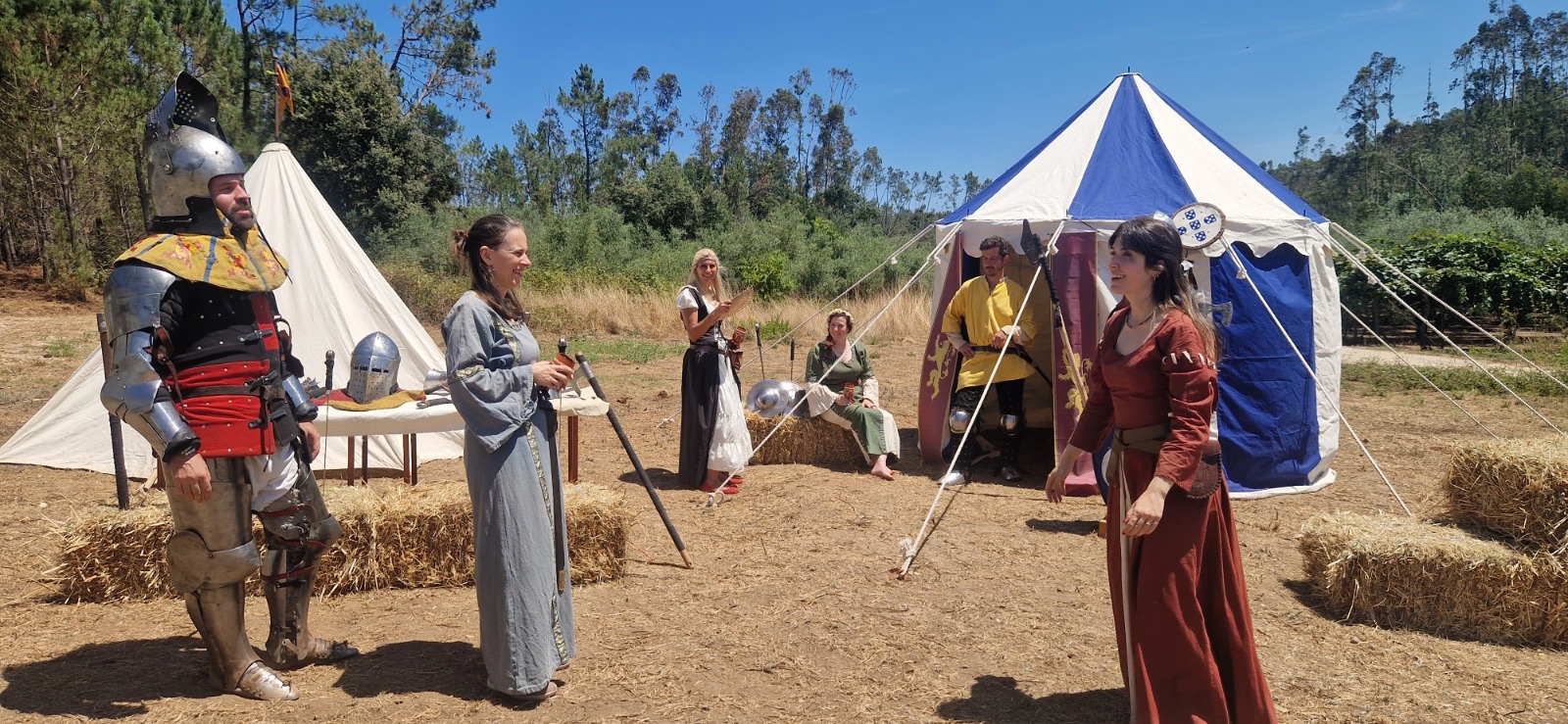 Acampamento medieval com tendas, figurantes e armaduras