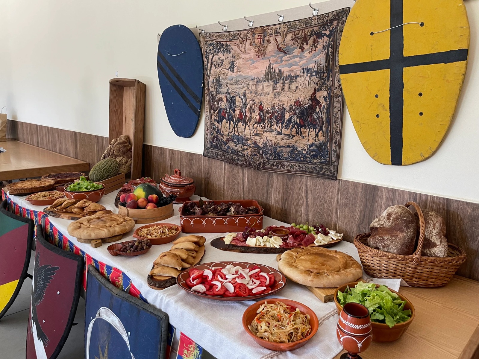 Mesa de banquete medieval com comida e decoração histórica